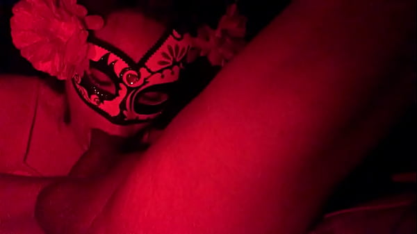 Masked in the red light sucking cock